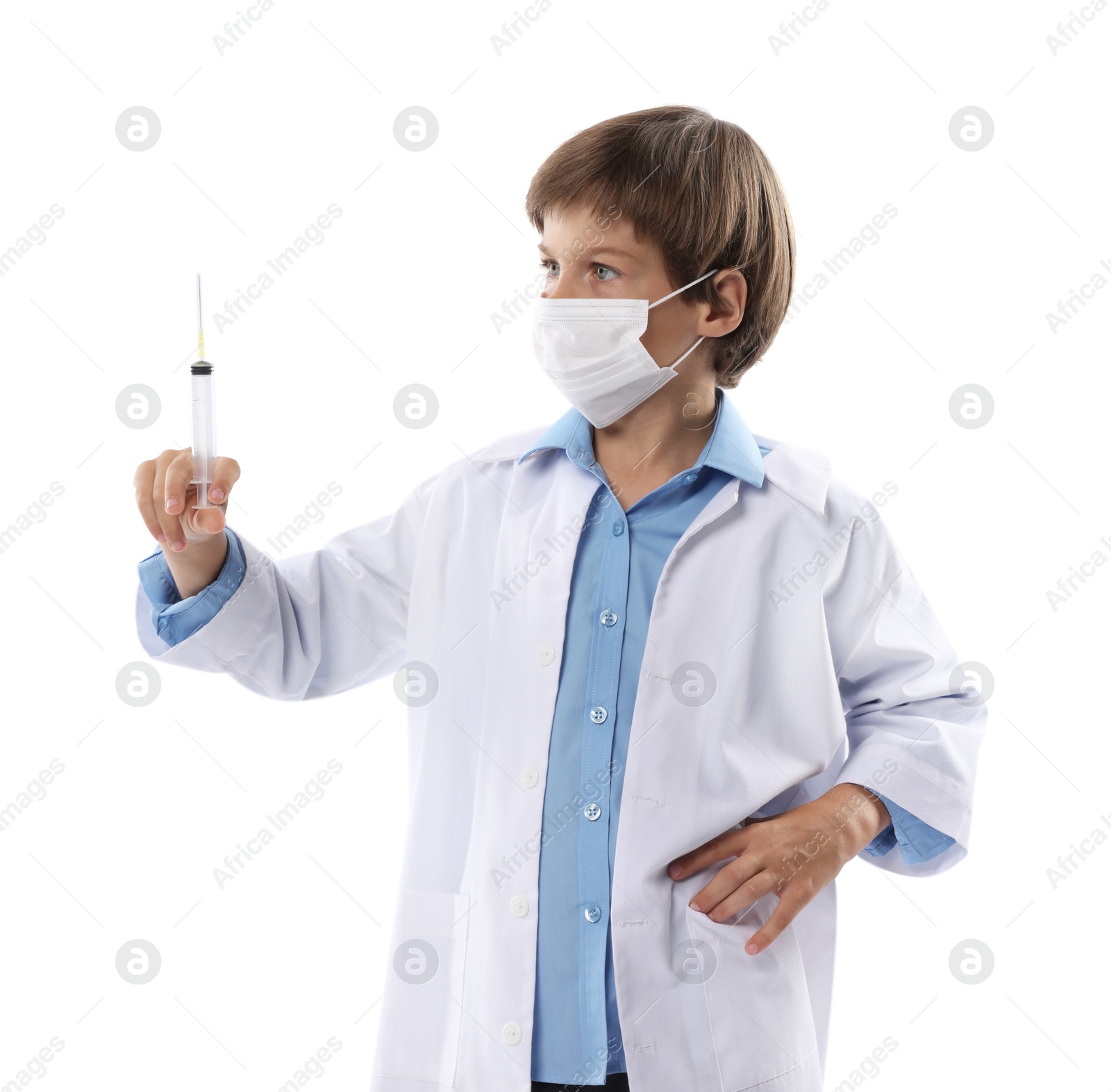 Photo of Choice of profession. Little boy in medical mask with syringe pretending to be doctor on white background