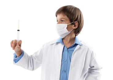 Photo of Choice of profession. Little boy in medical mask with syringe pretending to be doctor on white background