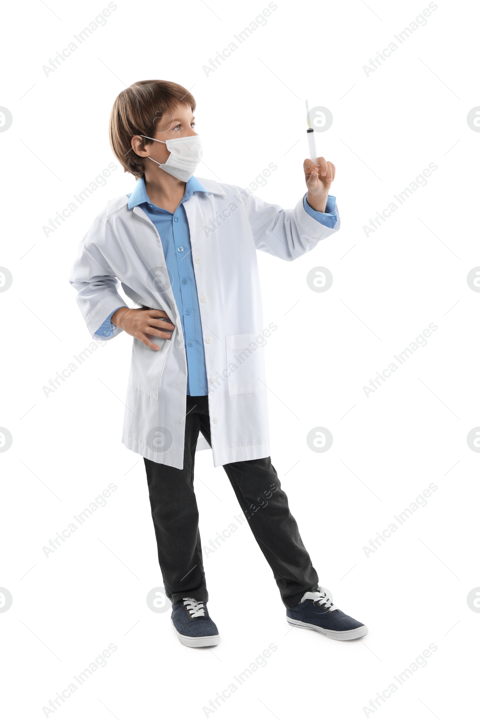Photo of Choice of profession. Little boy in medical mask with syringe pretending to be doctor on white background
