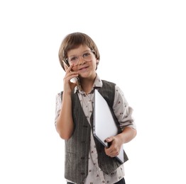 Photo of Choice of profession. Happy little boy in glasses talking by smartphone pretending to work with laptop on white background