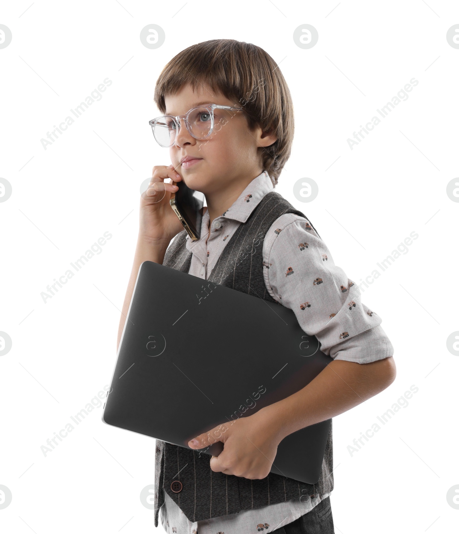 Photo of Choice of profession. Little boy in glasses talking by smartphone pretending to work with laptop on white background