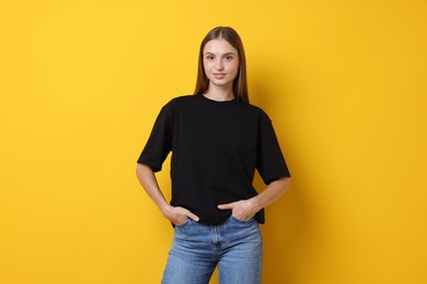 Photo of Woman wearing stylish black t-shirt on yellow background