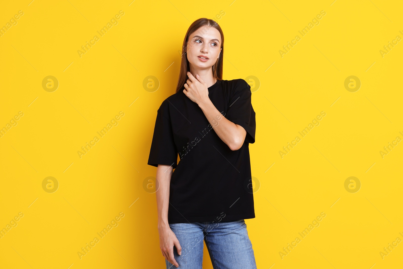 Photo of Woman wearing stylish black t-shirt on yellow background