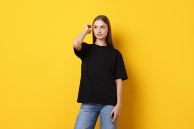 Photo of Woman wearing stylish black t-shirt on yellow background
