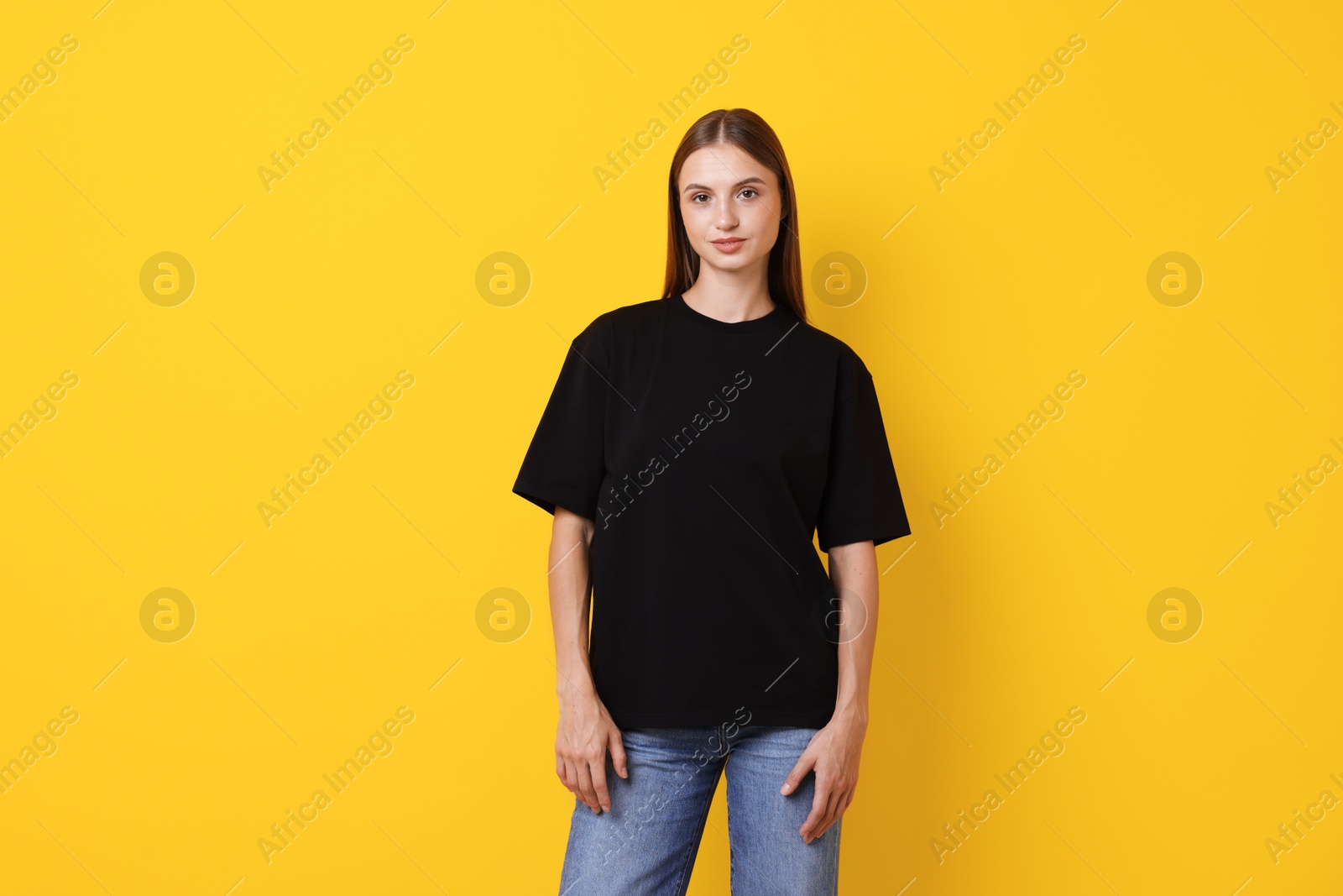 Photo of Woman wearing stylish black t-shirt on yellow background
