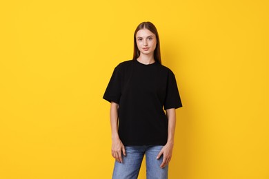 Photo of Woman wearing stylish black t-shirt on yellow background
