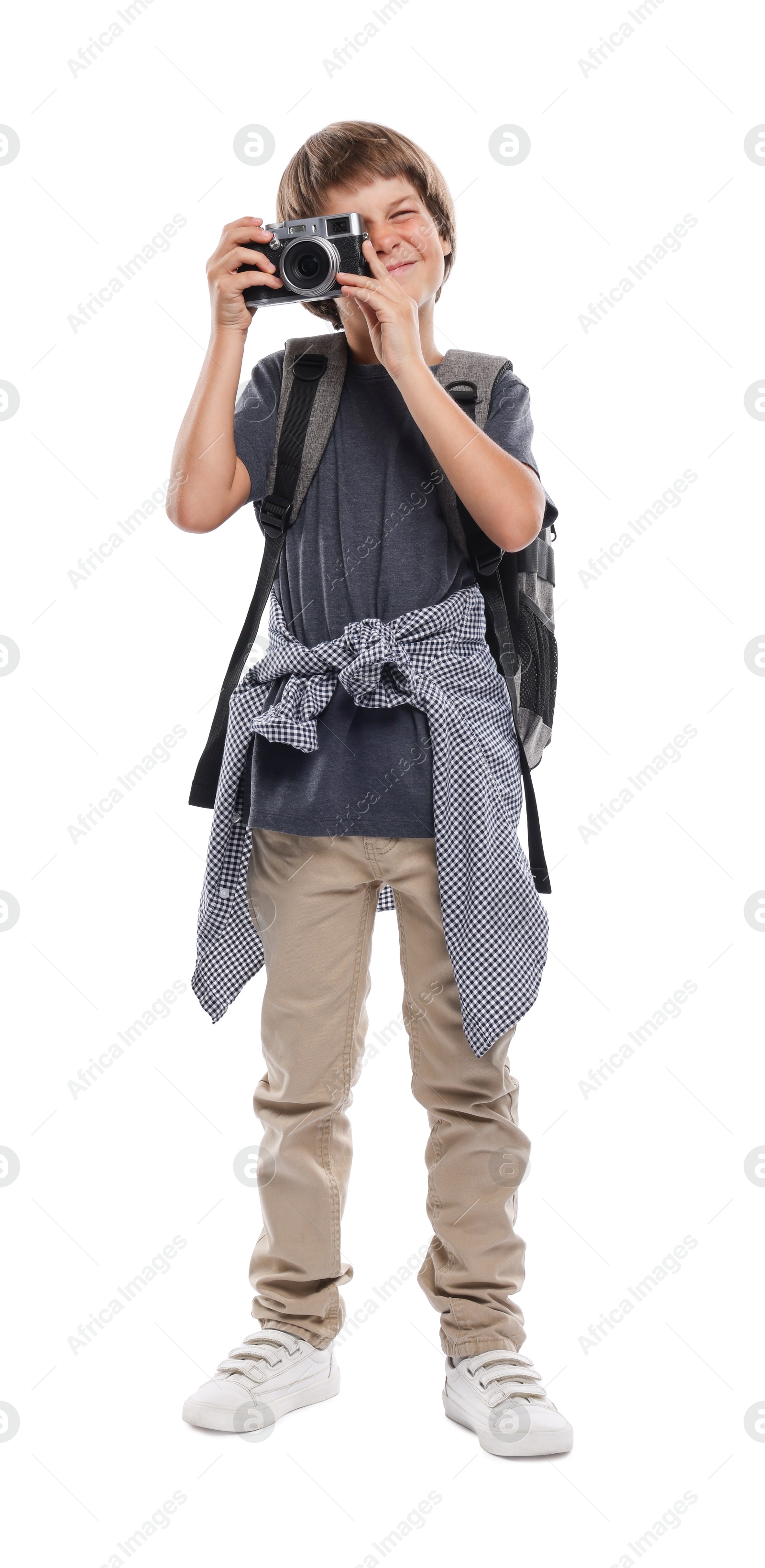 Photo of Choice of profession. Little boy with camera and backpack pretending to be photographer on white background