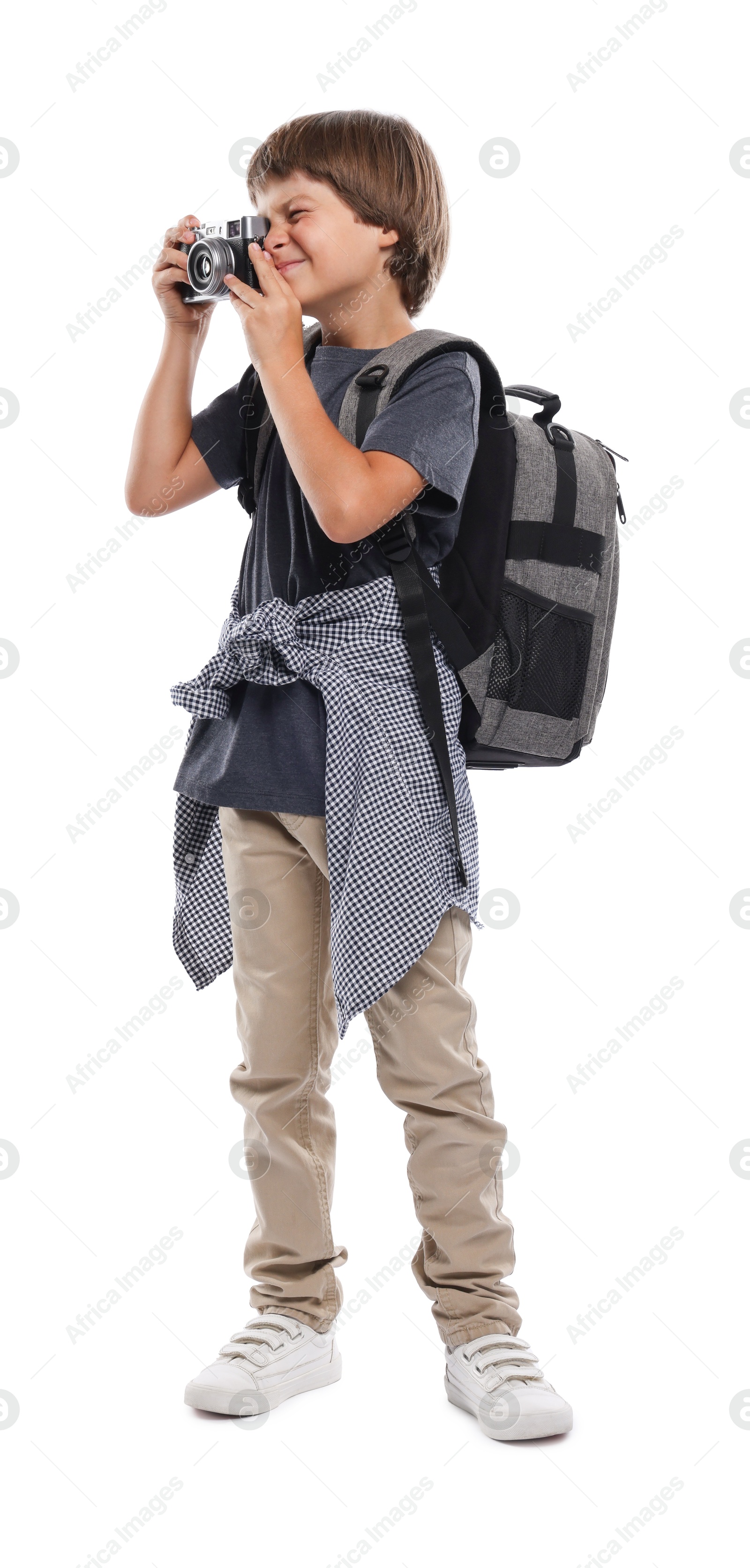 Photo of Choice of profession. Little boy with camera and backpack pretending to be photographer on white background
