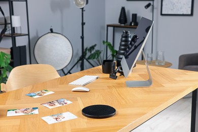 Photo of Pictures and computer on wooden table in studio