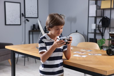 Photo of Choice of profession. Little boy with camera pretending to be photographer in studio