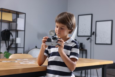 Photo of Choice of profession. Little boy with camera pretending to be photographer in studio