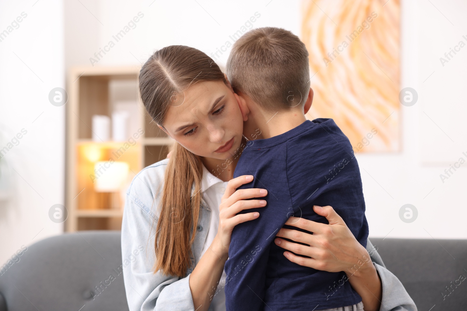 Photo of Mother supporting and hugging her upset son at home