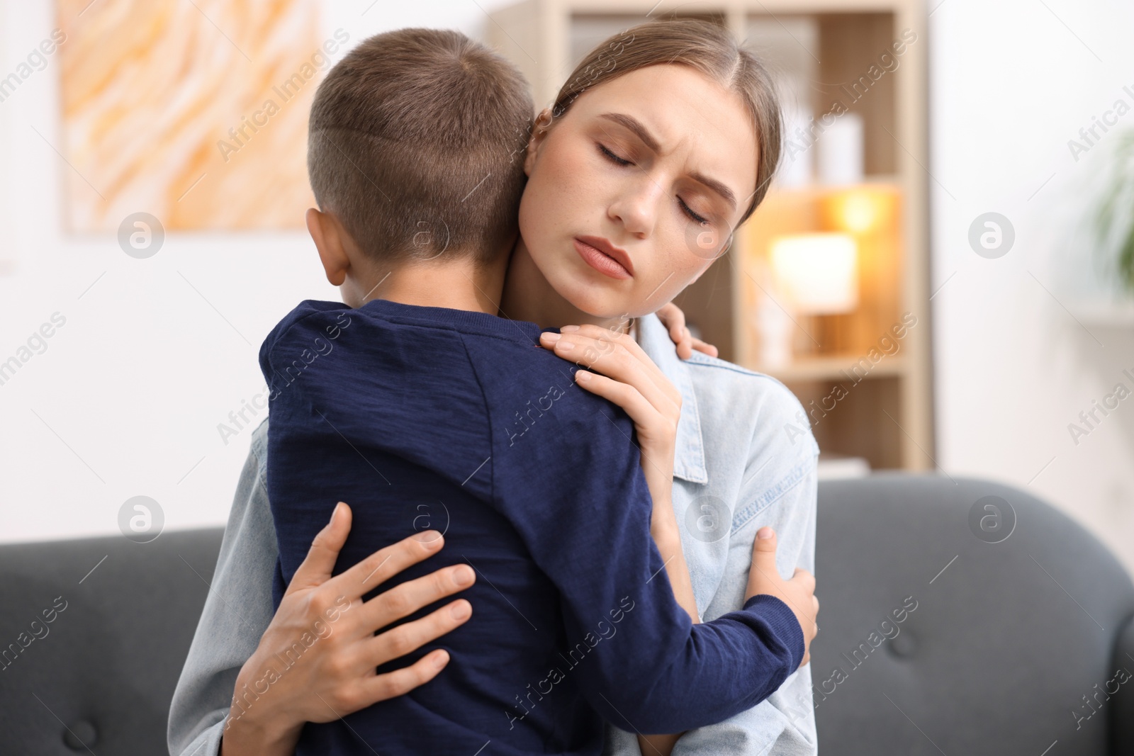 Photo of Mother supporting and hugging her upset son at home
