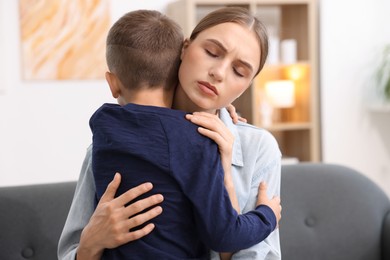 Photo of Mother supporting and hugging her upset son at home