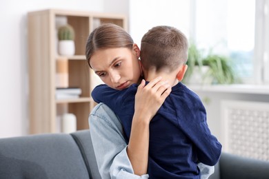 Photo of Mother supporting and hugging her upset son at home