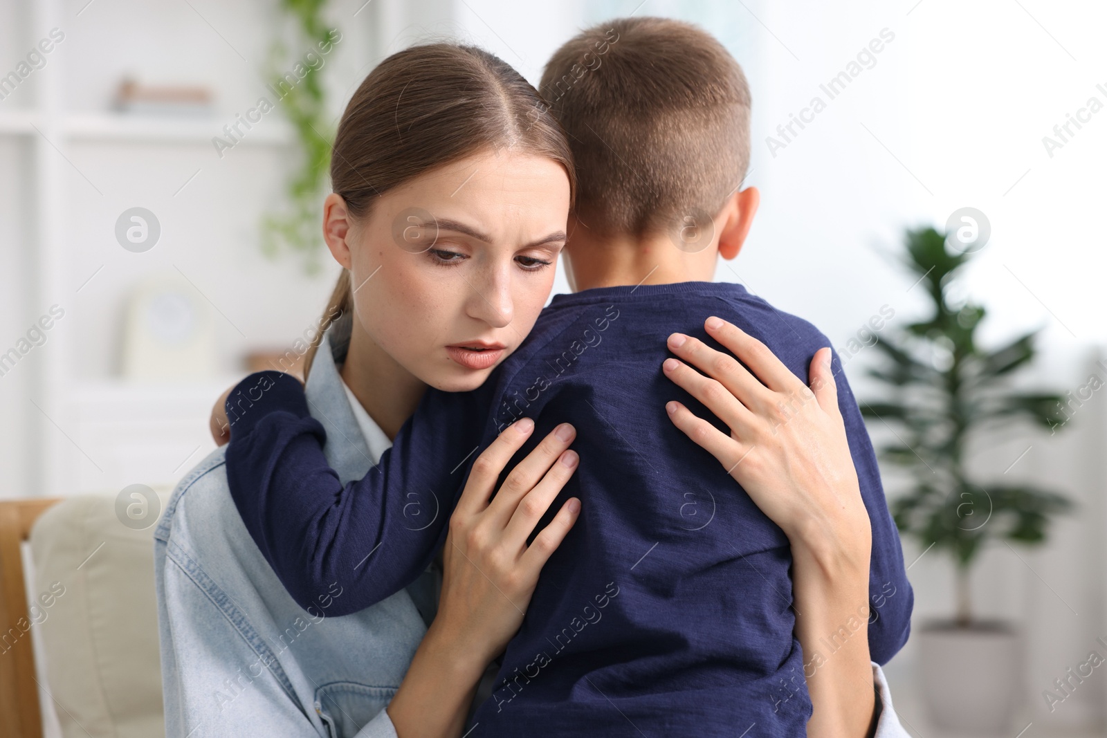 Photo of Mother supporting and hugging her upset son at home