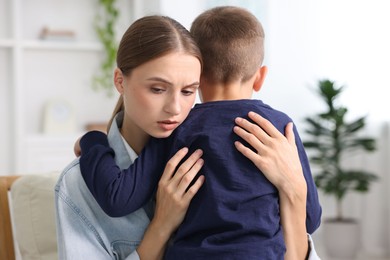 Photo of Mother supporting and hugging her upset son at home
