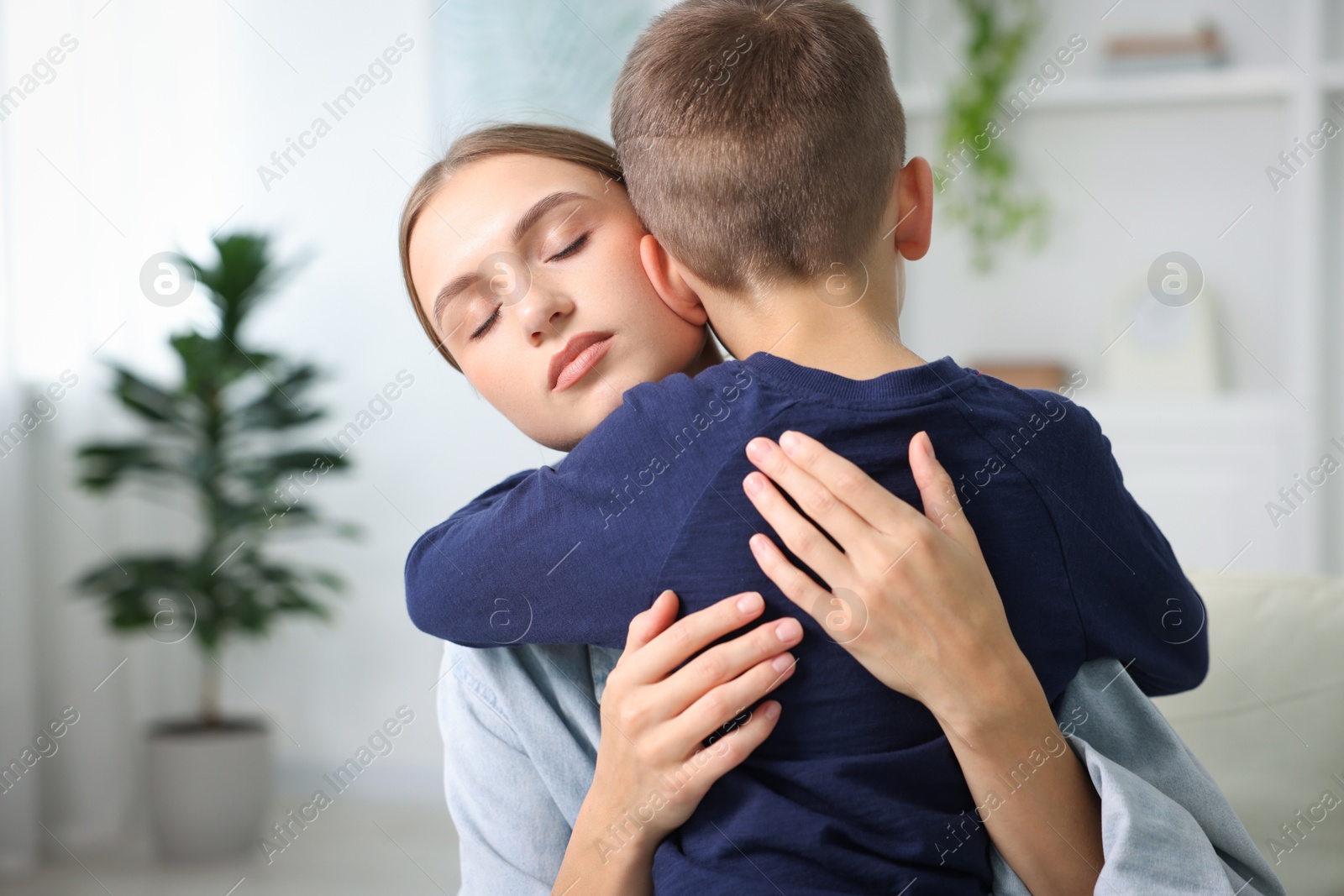 Photo of Mother supporting and hugging her upset son at home