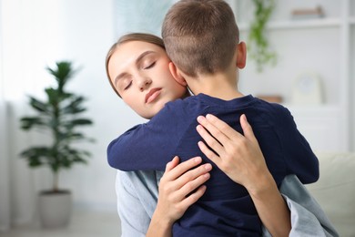 Photo of Mother supporting and hugging her upset son at home