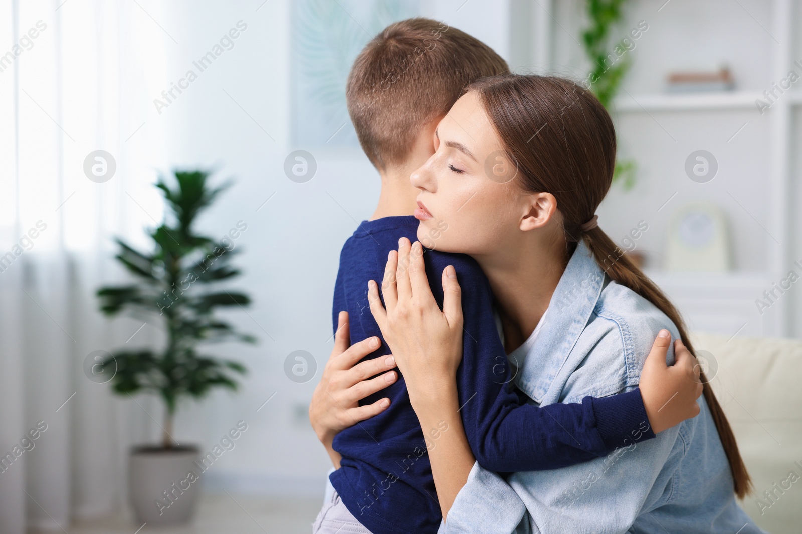 Photo of Mother supporting and hugging her upset son at home