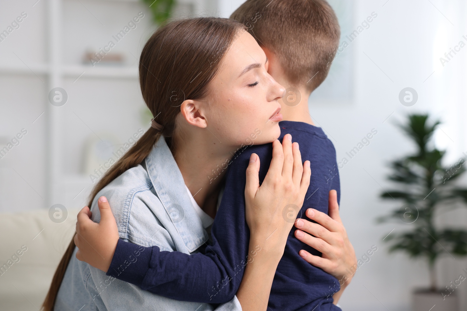 Photo of Mother supporting and hugging her upset son at home