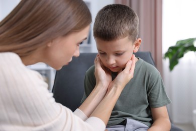 Photo of Mother supporting her upset son at home, closeup