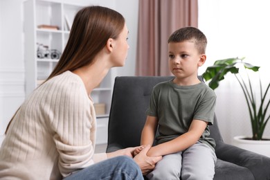 Photo of Mother supporting and holding hands with her upset son at home