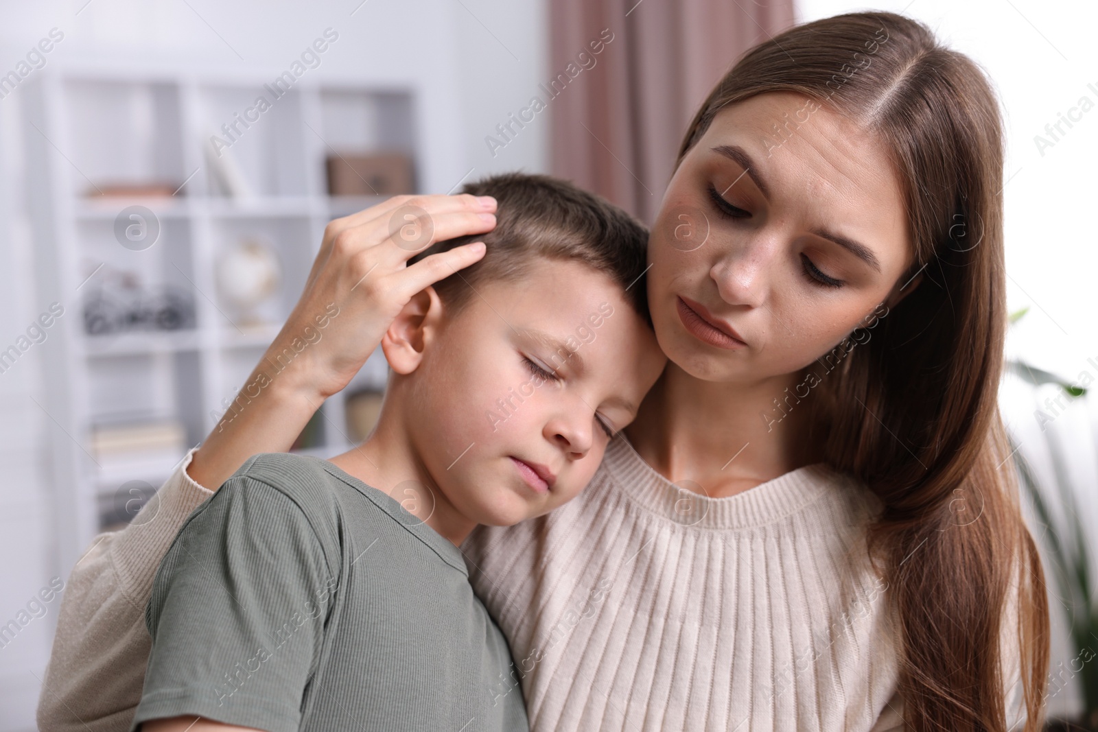 Photo of Mother supporting and hugging her upset son at home