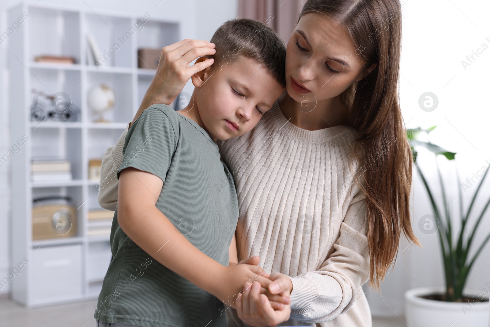 Photo of Mother supporting and hugging her upset son at home