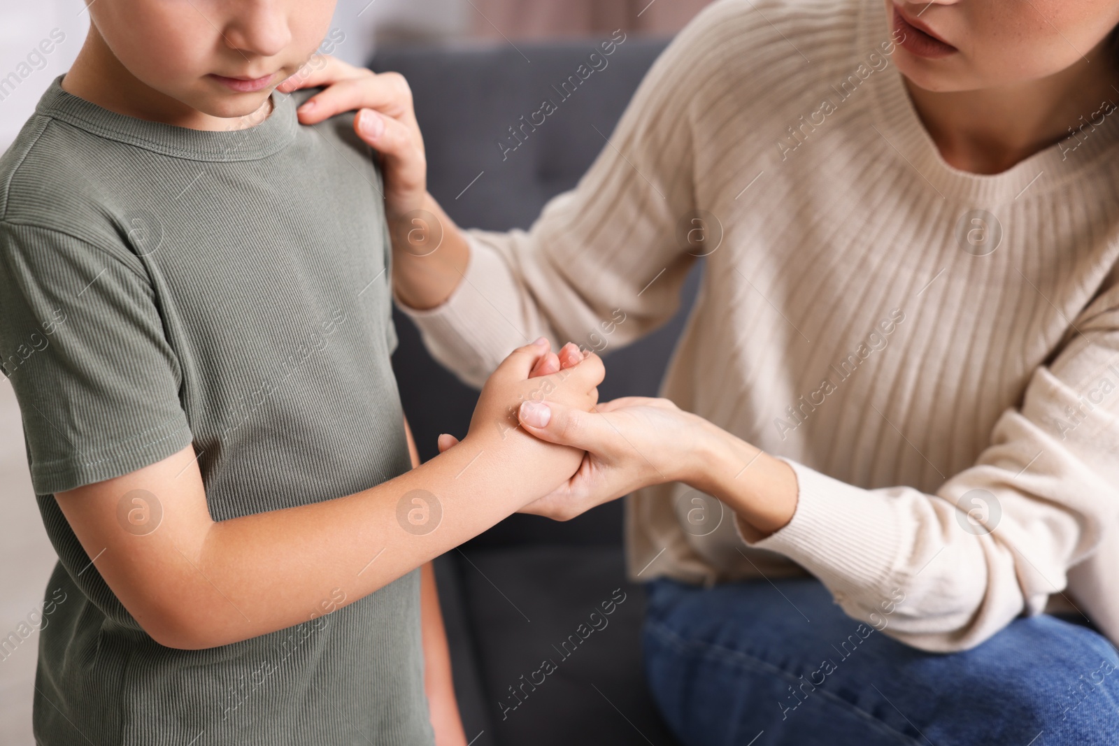 Photo of Mother supporting her upset son at home, closeup