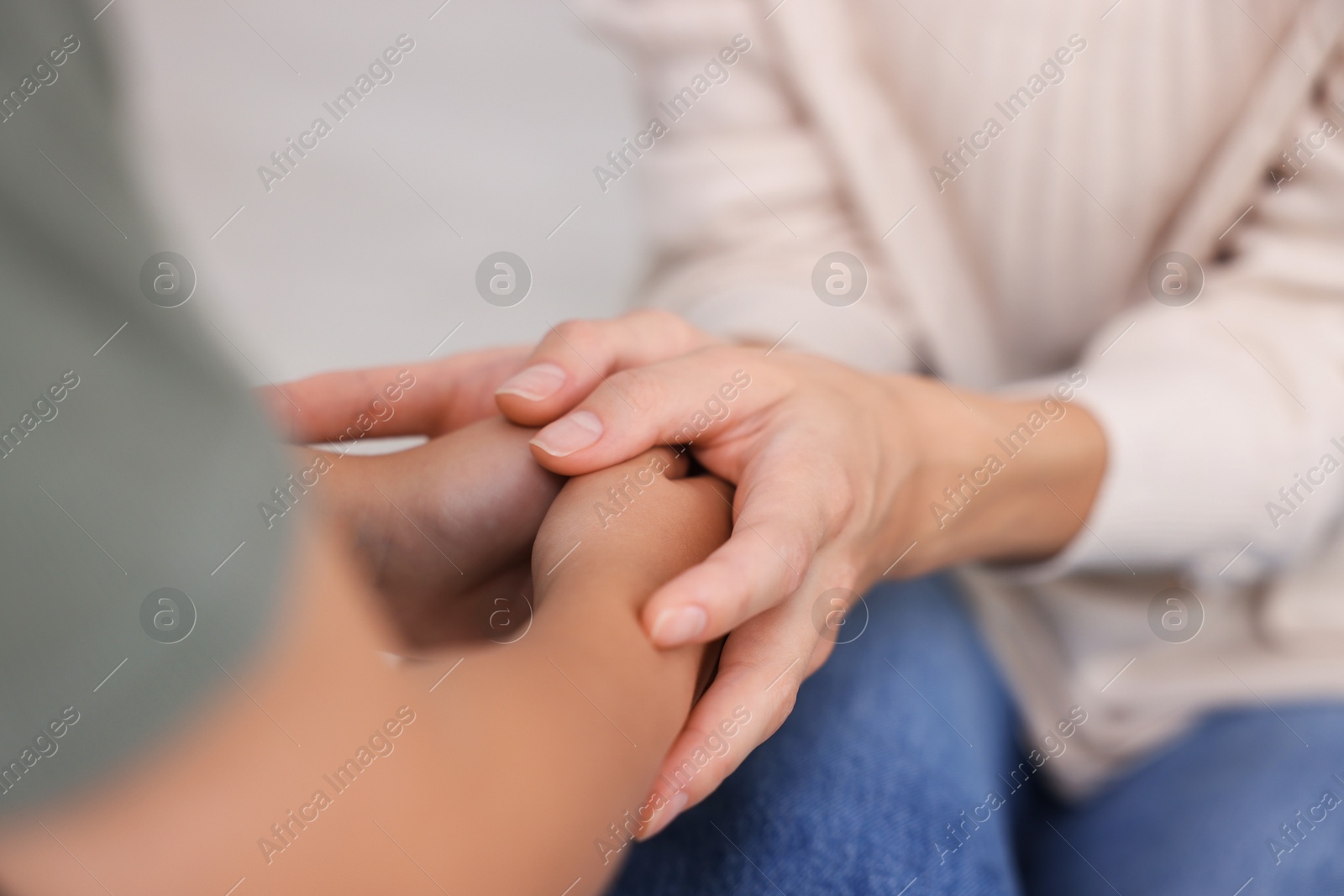 Photo of Mother supporting and holding hands with her son at home, closeup