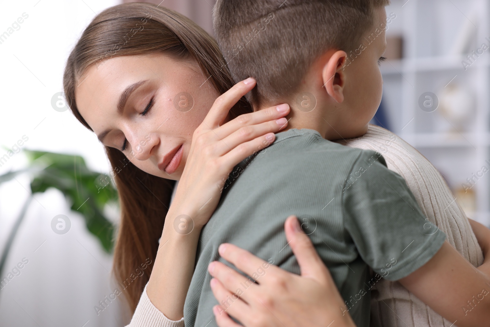 Photo of Mother supporting and hugging her upset son at home