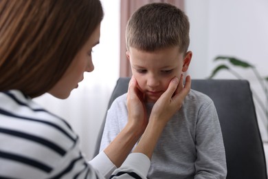 Photo of Mother supporting her upset son at home, closeup