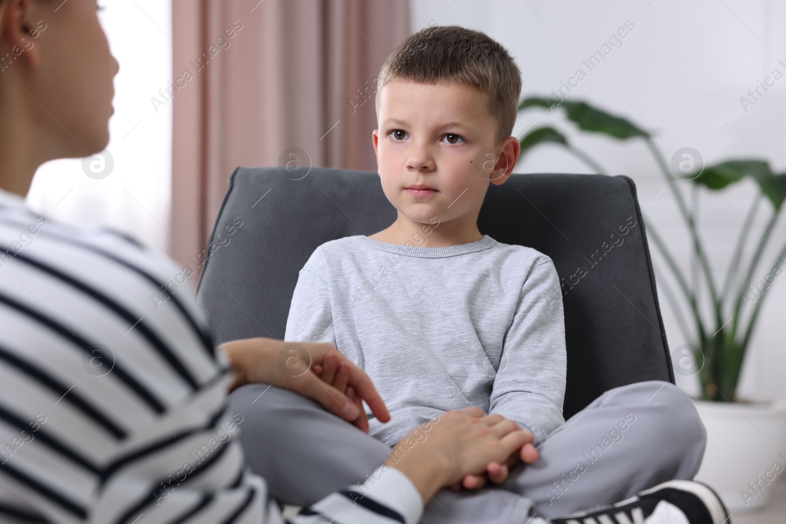 Photo of Mother supporting her upset son at home, closeup