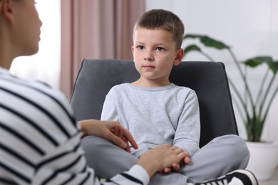 Photo of Mother supporting her upset son at home, closeup