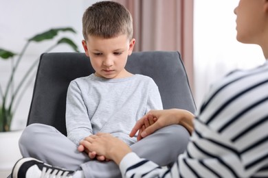 Photo of Mother supporting her upset son at home, closeup