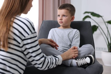 Photo of Mother supporting her upset son at home, closeup
