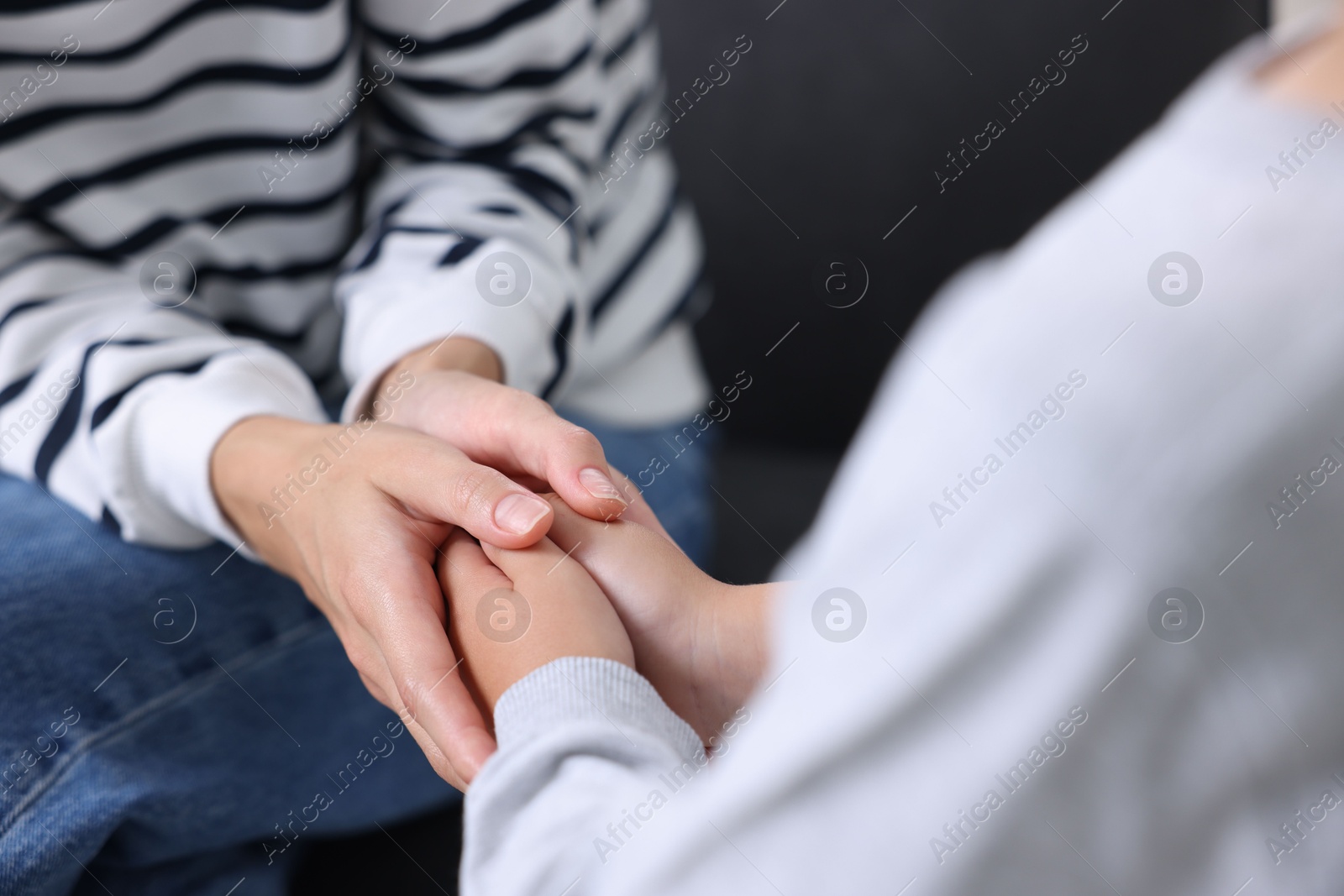 Photo of Mother supporting and holding hands with her son at home, closeup