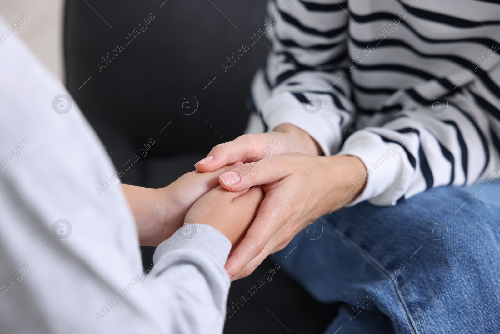 Photo of Mother supporting and holding hands with her son at home, closeup