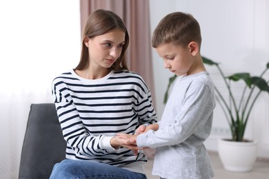 Photo of Mother supporting and holding hands with her upset son at home