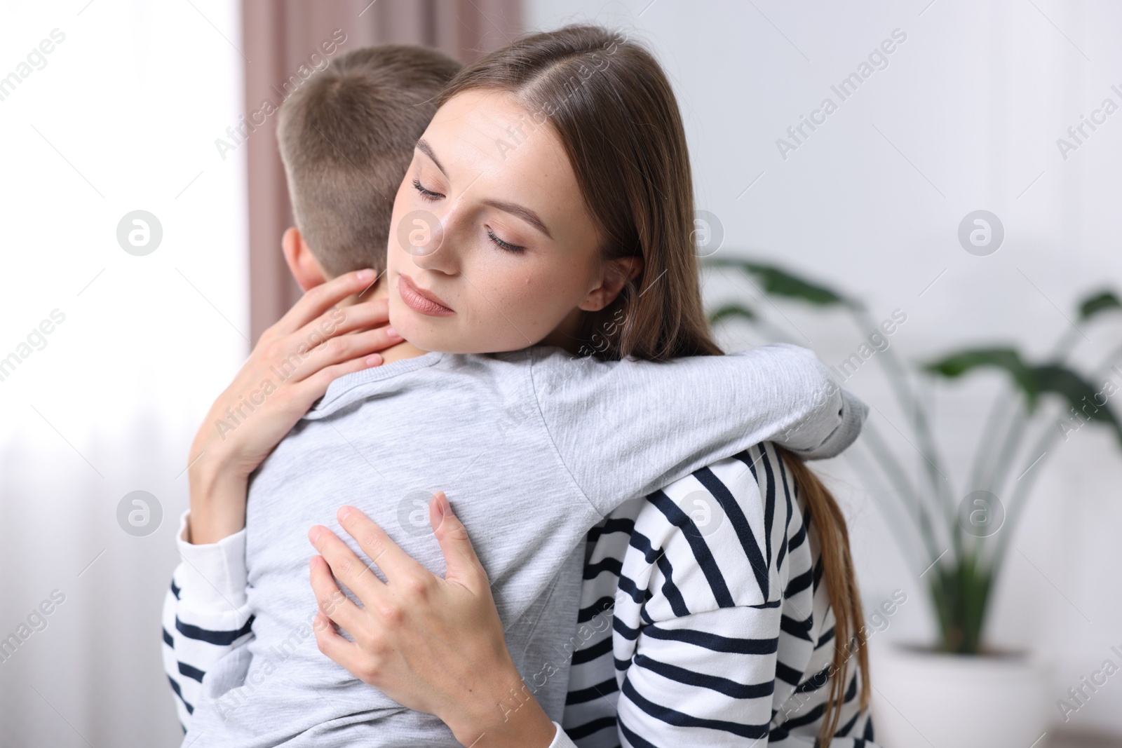 Photo of Mother supporting and hugging her upset son at home