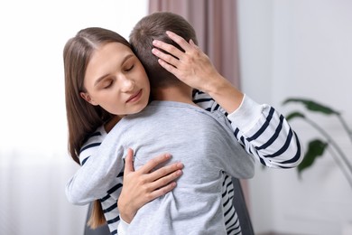 Photo of Mother supporting and hugging her upset son at home