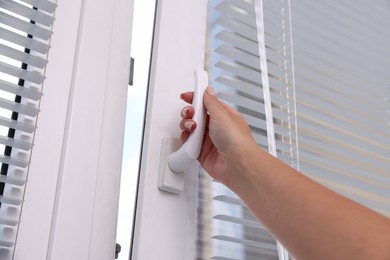 Photo of Woman opening window at home, low angle view