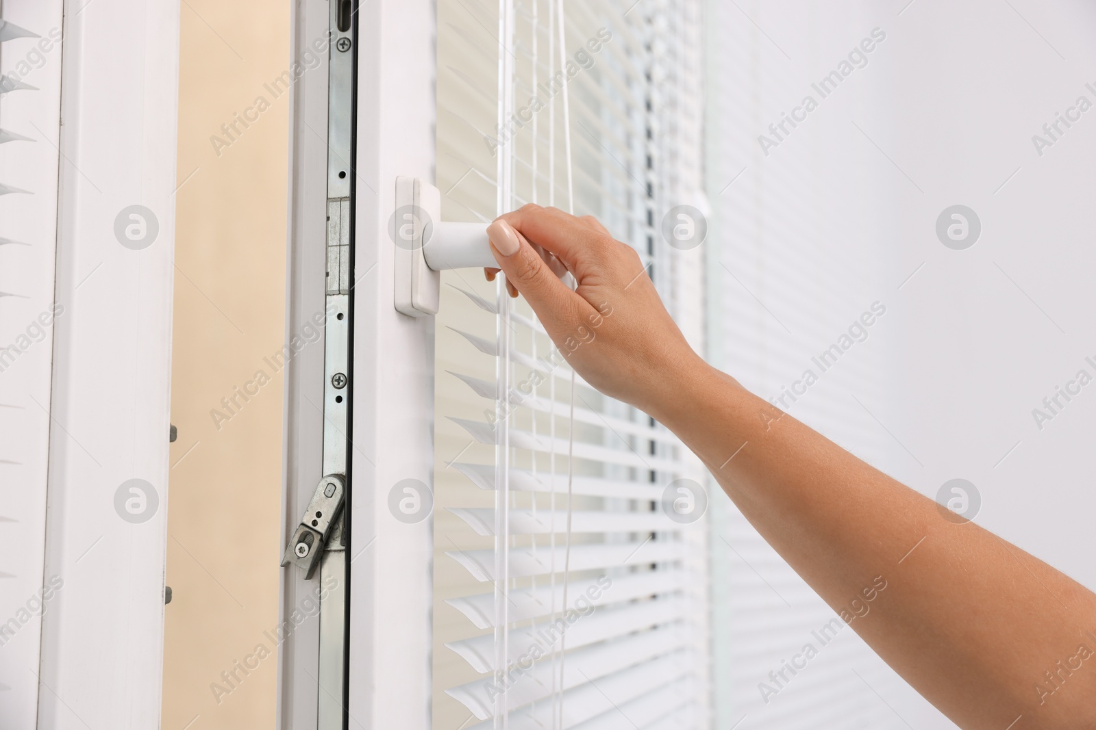 Photo of Woman opening modern window at home, closeup