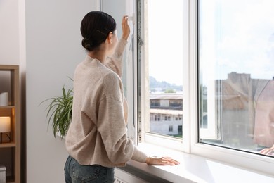 Photo of Young woman opening modern window at home