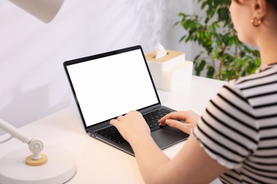 Photo of Woman working with laptop at white table indoors, closeup. Mockup for design