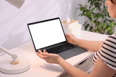 Photo of Woman working with laptop at white table indoors, closeup. Mockup for design