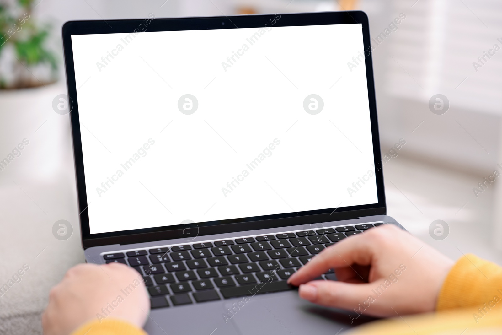 Photo of Woman working with laptop indoors, closeup. Mockup for design