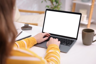 Photo of Woman working with laptop at white table indoors, closeup. Mockup for design