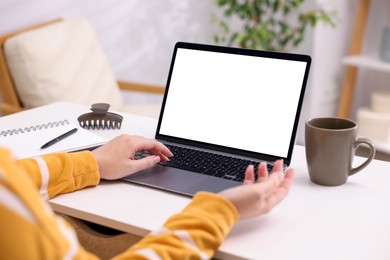 Photo of Woman working with laptop at white table indoors, closeup. Mockup for design